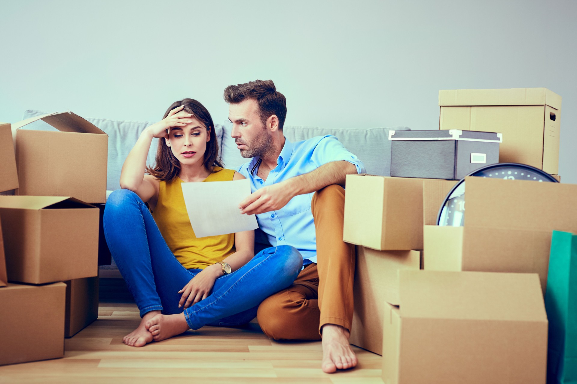 Worried couple reading agreement after moving to new home