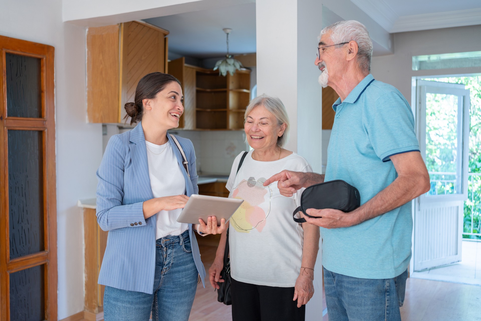 Real Estate Agent Showing Three Dimensional Plan Of A House To Senior Couple On Digital Tablet